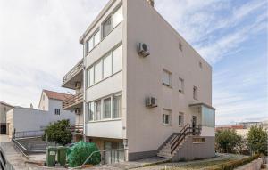 a tall white building with stairs on it at Pet Friendly Apartment In Podstrana in Podstrana