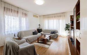 a living room with two couches and a table at Pet Friendly Apartment In Podstrana in Podstrana +12 photos