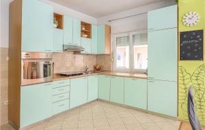 a kitchen with blue cabinets and a window at Pet Friendly Apartment In Podstrana in Podstrana