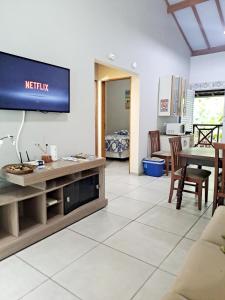 a living room with a tv on a wall at Casa do Mar & Ane Ilhabela in Ilhabela