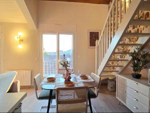 a dining room with a table and chairs and a staircase at Marmande centre - 4pers in Marmande