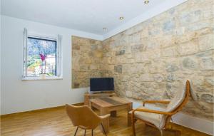 オミシュにあるAmazing Home In Omis With Wifiの石壁のリビングルーム(デスク、椅子付)