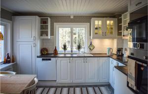 a kitchen with white cabinets and a window at 2 Bedroom Pet Friendly Home In Burseryd in Sjötofta