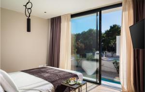 a bedroom with a bed and a large window at Villa Viktoria in Pakoštane