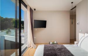 a bedroom with a bed and a tv on the wall at Villa Viktoria in Pakoštane