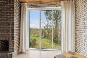 a room with a large window and a brick wall at Cozy Holiday Home In Thisted in Thisted