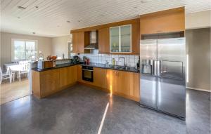 a kitchen with wooden cabinets and stainless steel appliances at 2 Bedroom Cozy Home In Traryd in Traryd