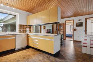 a kitchen with white cabinets and a wooden ceiling at Cozy Holiday Home In Thisted in Thisted +4 photos