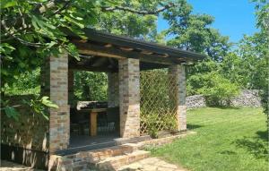 un pavillon en briques avec une table dans un jardin dans l'établissement Villa Natural, à Žminj