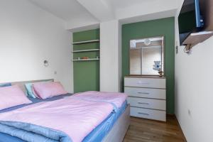 a bedroom with a bed and a dresser and a television at Skopje&Joy Central Flat in Skopje