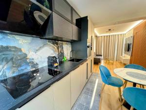 a kitchen with a counter and a table and chairs at L'Escale - CDG - Parking - Confort in Louvres