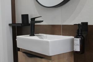 a white sink in a bathroom with a mirror at Entre Linhas in Coimbra