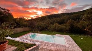 a swimming pool in a yard with a sunset at Vista Verde - Private house with 3 bedrooms & 3 bathrooms in Oreshak