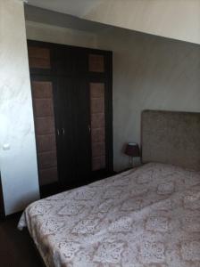 a bedroom with a bed with a white bedspread at Банско in Bansko