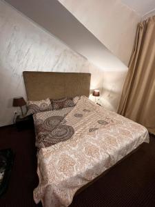 a bedroom with a large bed with a white comforter at Банско in Bansko