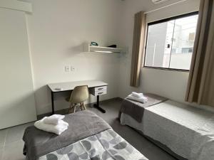 a room with two beds and a desk and a window at Residecial Málaga 01 in Sinop