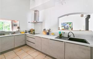 a kitchen with white cabinets and a sink in it at Stunning Home In Maubec With Wifi in Maubec
