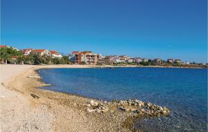a sandy beach with houses in the background at Beautiful Apartment In Povljana in Povljana