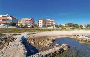 a beach with some rocks and some buildings at Beautiful Apartment In Povljana in Povljana +23 photos