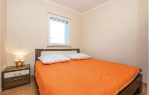 a bedroom with an orange bed and a window at Beautiful Apartment In Povljana in Povljana