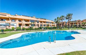 a swimming pool in front of a large apartment building at 2 Bedroom Amazing Apartment In Casares in Casares +10 photos