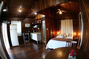a bedroom with a bed in a room with wooden walls at Chale Hortensia in Juquitiba