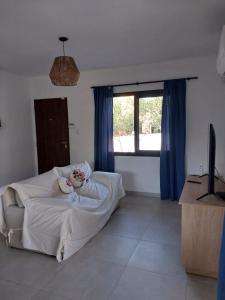 a bedroom with a white bed and a window at Altos de Las Sierras in Cosquín
