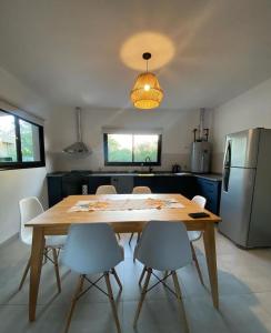 a kitchen with a wooden table with chairs and a refrigerator at Altos de Las Sierras in Cosquín