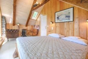 a bedroom with a large bed in a room with wooden walls at Forest eco-house & spa in Dolenja Ravan