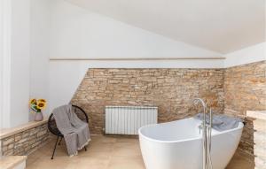 Łazienka z białą wanną i ceglaną ścianą w obiekcie Awesome Home In Vodnjan With Jacuzzi w mieście Mednjan +35 zdjęć