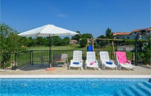 eine Gruppe von Stühlen und einem Sonnenschirm neben einem Pool in der Unterkunft Awesome Home In Nedescina With Wifi in Nedeščina + 45 Fotos