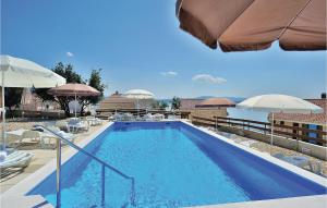 a swimming pool with chairs and umbrellas at Apartment Pavlinka Bb Iv in Posedarje