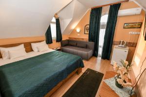 a hotel room with a bed and a couch at Lagúna Panzio Szántód in Szántód