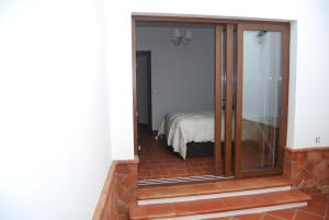 コンスタンティナにあるApartamentos Bodeguetasのベッドルームにつながるガラスドア付きの部屋
