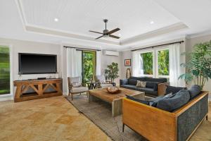 a living room with a couch and a tv at Chic Princeville Villa Private Pool Relaxation and AC in Princeville