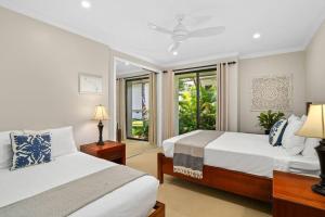 a bedroom with two beds and a window at Chic Princeville Villa Private Pool Relaxation and AC in Princeville