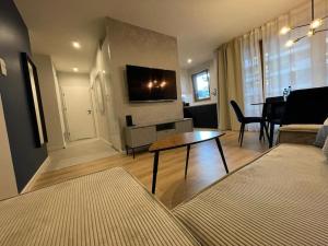 Televízia a/alebo spoločenská miestnosť v ubytovaní Apartment Wola Tower