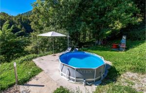 une petite piscine avec un parasol et un parasol dans l'établissement Awesome Apartment In Lokve, à Mrzla Vodica