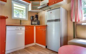 a small kitchen with an orange and white refrigerator at 3 Bedroom Nice Home In La Faute-Sur-Mer in La Faute-sur-Mer