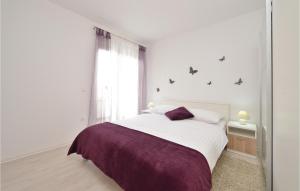 Biała sypialnia z dużym łóżkiem i fioletowym kocem w obiekcie Apartment Vrsi-Mulo 11 w mieście Kod Mula