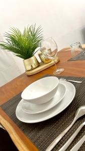 a wooden table with white plates and a wine glass at Charming two bedroom flat - NATO - Brussels in Brussels