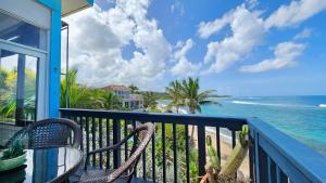 Un balcón con una mesa y una silla y el océano en LoveShack Villa in Shacks Beach, Isabela, en Isabela