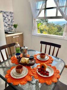 a glass table with plates of food on it at Red House - Casa com Linda vista do Mar in Palhoça