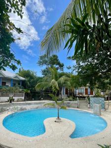 een blauw zwembad met een palmboom in het midden bij La Concepcion Cove Garden Resort in Moalboal +30 foto's