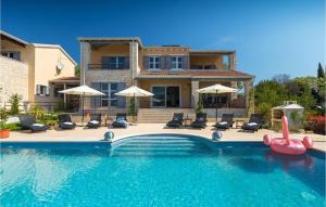 une maison avec une piscine avec chaises et parasols dans l'établissement Villa Nikolina, à Poreč