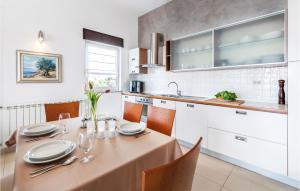 kuchnia ze stołem z talerzami i okularami w obiekcie 2 Bedroom Cozy Apartment In Banjole w mieście Banjole +31 zdjęć