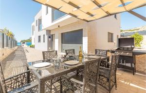 a patio with a table and chairs and a grill at Stunning Home In Sibenik - Zaboric in Zaboric