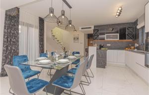 a dining room with a table and blue chairs at Stunning Home In Sibenik - Zaboric in Zaboric