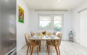 a white dining room with a white table and chairs at Awesome Home In Peroj in Peroj