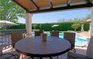 a table and chairs on a patio with a pool at Villa La Quercia in Poreč +30 photos